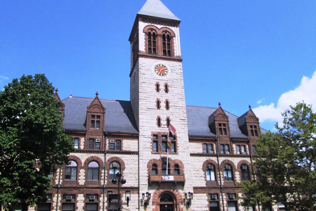 Cambridge City Hall in Cambridge, Massachusetts, with its clock tower rising above the main entrance.