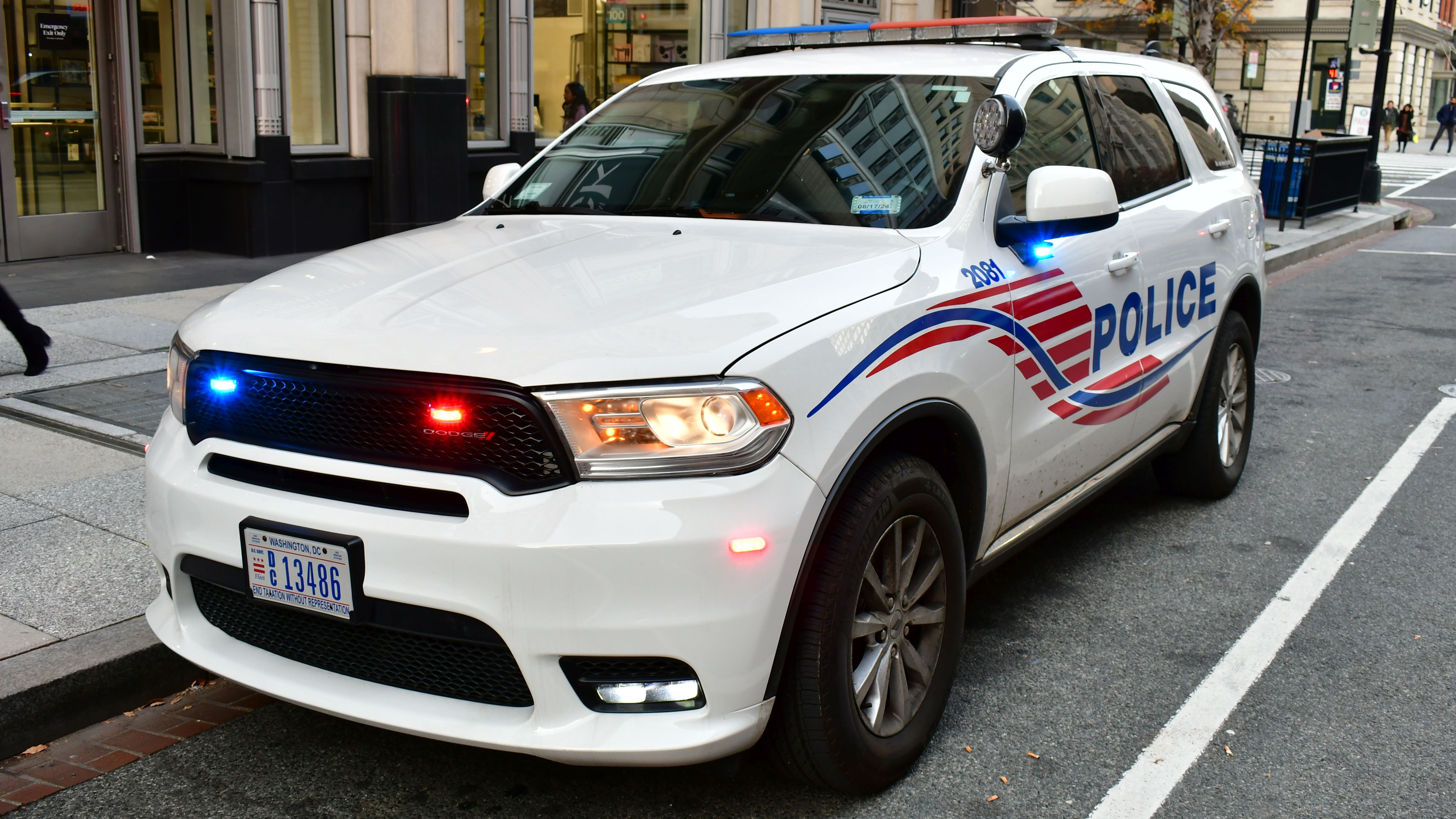 A D.C. Metropolitan Police SUV with red and blue emergency lights illuminated.