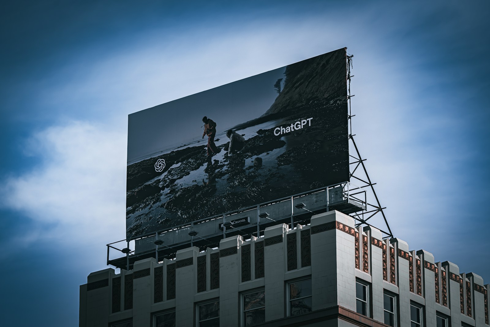 A ChatGPT billboard on a building in San Francisco beneath a cloudy blue sky.