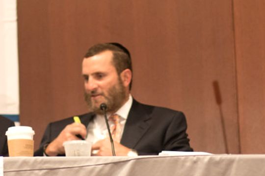 Shmuley Boteach speaking into a microphone at a 2014 event.